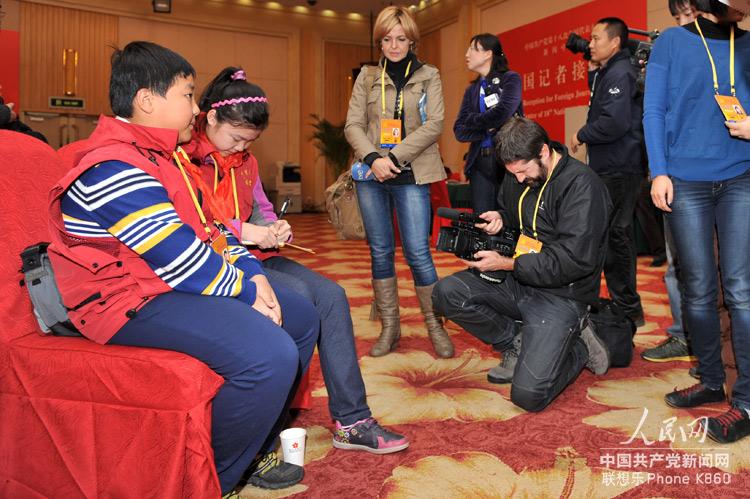 11月12日，在十八大新聞中心，兩位來自《中國少年報》的小記者引起了在場中外大記者的關注。人民網記者 翁奇羽 攝