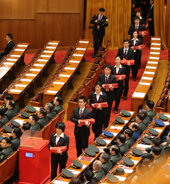  11月14日，中国共产党第十八次全国代表大会闭幕会在北京人民大会堂举行。这是工作人员手捧选票进入会场。新华社记者 丁林 摄