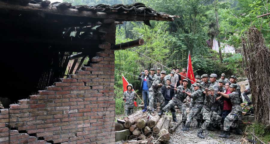 4月21日上午，記者在蘆山地震中心災區太平鎮，攝下了13軍某炮兵團官兵在幫助村民拆除危屋的情景。