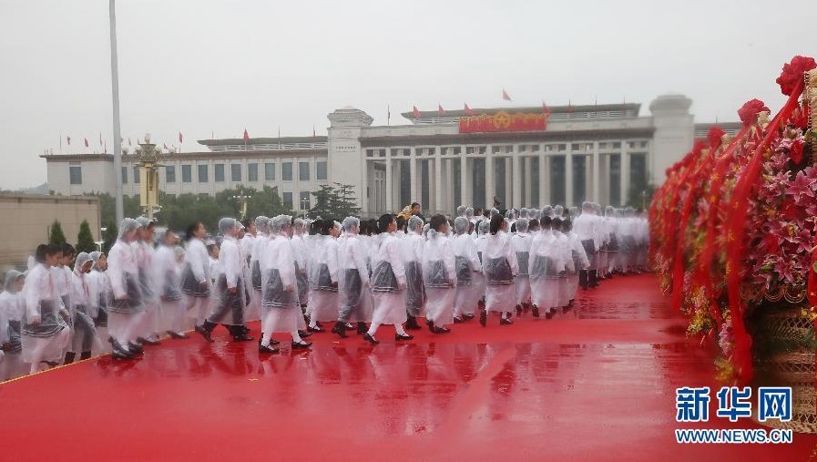 10月1日上午，首都各界代表向人民英雄紀念碑敬獻花籃儀式在北京天安門廣場舉行。這是代表冒雨瞻仰人民英雄紀念碑。 新華社記者姚大偉攝