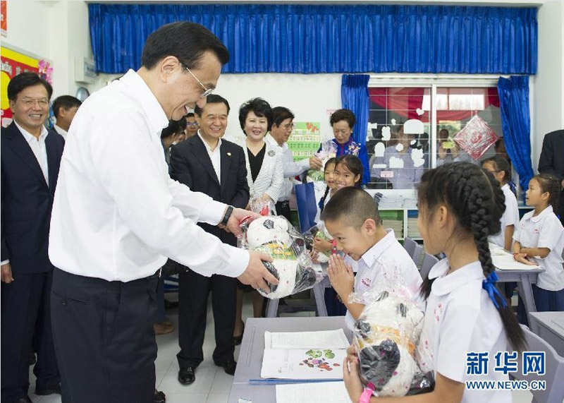 10月13日，正在泰國訪問的國務院總理李克強參觀具有110多年歷史的清邁崇華新生華立學校。這是李克強向三年級學生贈送大熊貓玩具。新華社記者 黃敬文 攝