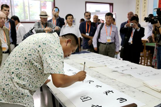 9月5日，代表團在曲阜小雪街道武家村文化大院觀看當地藝術家撰寫書法。（崔小粟 攝）