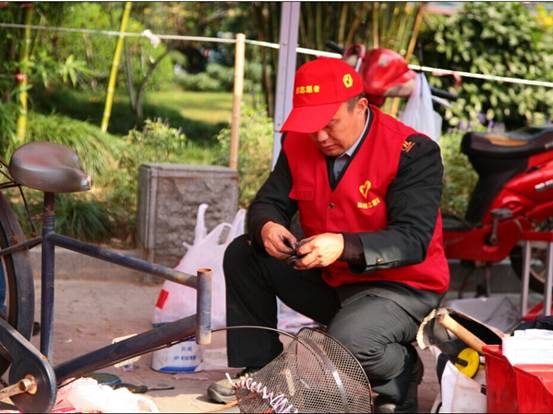 全國黨代表、全國勞模、杭州城投系統志願服務副總隊長、公交駕駛員孔勝東在修理自行車