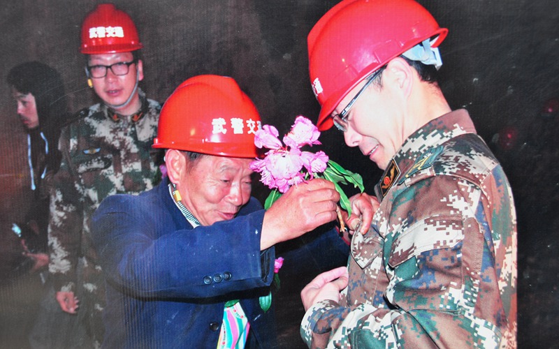 隧道貫通之際，高德榮滿心欣喜為武警戰士獻上杜鵑花。