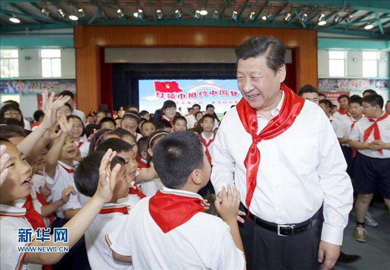 2014年5月30日上午，习近平来到北京市海淀区民族小学，参加庆祝“六一”国际儿童节活动。这是习近平在参加少先队入队仪式时，向少先队员们致以节日问候。新华社记者 鞠鹏 摄