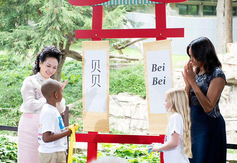 9月25日，國家主席習近平夫人彭麗媛同美國總統奧巴馬夫人米歇爾在華盛頓共同參觀美國國家動物園大熊貓館。這是彭麗媛與米歇爾共同為大熊貓幼崽選定名字“貝貝”。新華社記者 王曄 攝