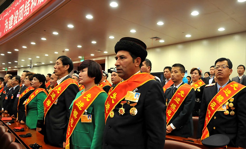 10月1日，庆祝中华人民共和国成立66周年暨新疆维吾尔自治区成立60周年大会在新疆人民会堂举行。图为大会现场全体起立唱国歌。新华网记者 王新彪 摄