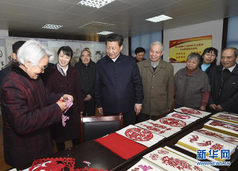 这是15日上午，习近平在西安市雁塔区电子城街道二〇五所社区服务中心观看社区居民的剪纸艺术。新华社记者 李学仁 摄