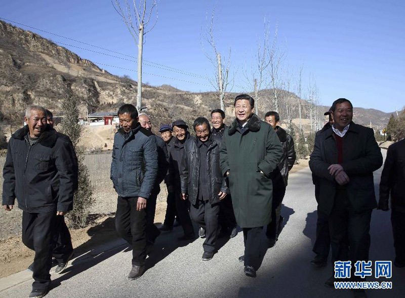 这是13日上午，习近平在延安市延川县文安驿镇梁家河村调研时同村民边走边聊。新华社记者 兰红光 摄