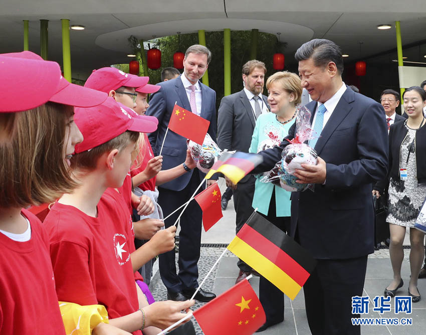 7月5日，國家主席習近平同德國總理默克爾共同出席柏林動物園大熊貓館開館儀式。這是習近平向現場的孩子們贈送大熊貓毛絨玩具。 新華社記者謝環馳 攝
