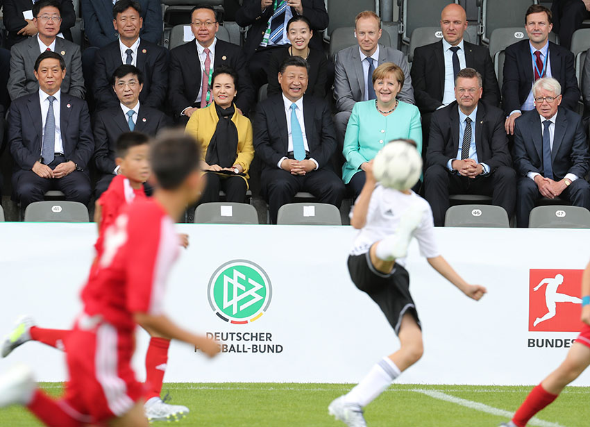 7月5日，國家主席習近平在柏林同德國總理默克爾共同觀看中德青少年足球友誼賽。這是習近平和夫人彭麗媛同默克爾在看台上。 新華社記者 王曄攝