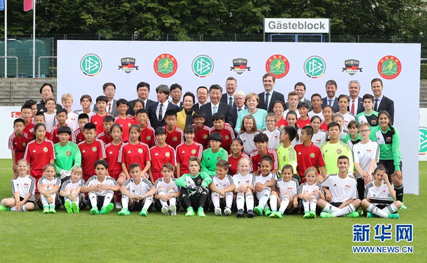 7月5日，國家主席習近平在柏林同德國總理默克爾共同觀看中德青少年足球友誼賽。這是習近平和夫人彭麗媛同默克爾與雙方小球員合影。新華社記者 王曄 攝