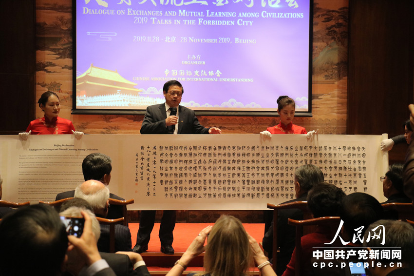 中國國際交流協會副會長徐裡展示書法版文明交流互鑒對話會成果文件。（中國共產黨新聞網 任佳暉攝）