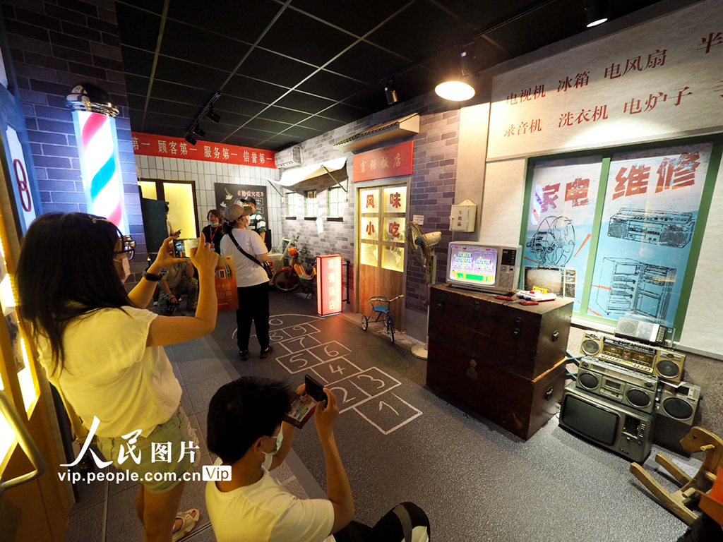 2021年6月22日，觀眾在“復興大道100號”創意體驗館內的“富民大街”場景內參觀。“富民大街”場景將上世紀80、90年代的街景進行還原 ，展現了改革開放以來，在黨的帶領下,我國經濟迅速發展，人民生活極大改善、精神生活日漸豐富的景象。