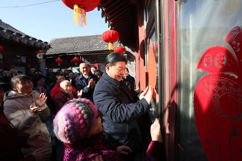 2019年2月1日上午，习近平在北京前门东区草厂四条胡同32号院，高兴地拿起一幅“福”字，亲自贴到门上，给这里的老街坊们拜年。新华社记者 鞠鹏 摄