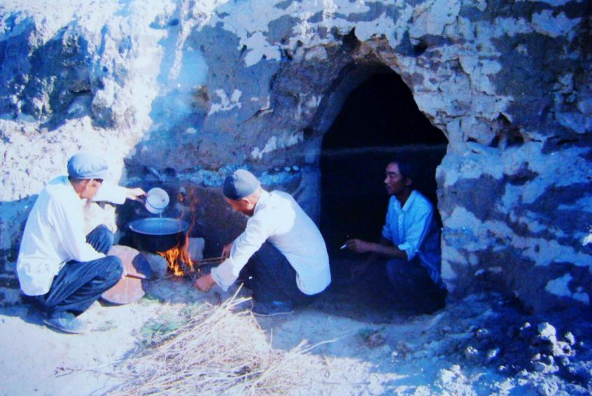 1983年，“六老汉”一代治沙人在“地窝子”生活做饭。新华社发（八步沙林场供图）