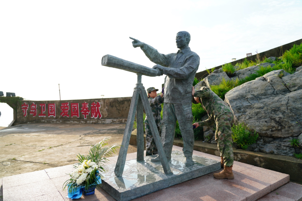 王仕花與開(kāi)山島民兵哨所所長(zhǎng)陳志顯一起擦拭王繼才銅像（2023年7月27日攝）。李弘非 攝