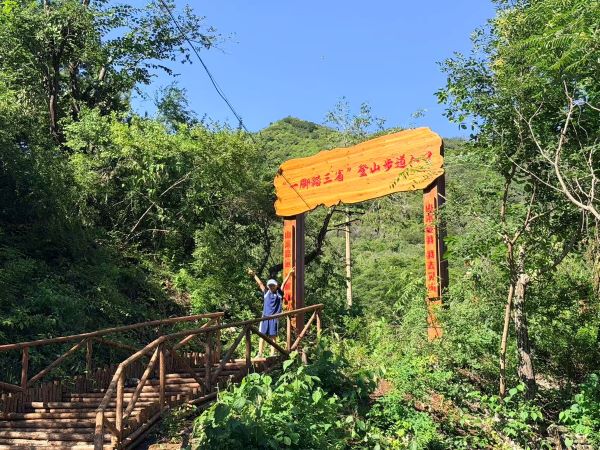 游客在北京市平谷区大岭后村“一脚踏三省”登山步道入口处拍照留念。北京市平谷区夏各庄镇人民政府供图