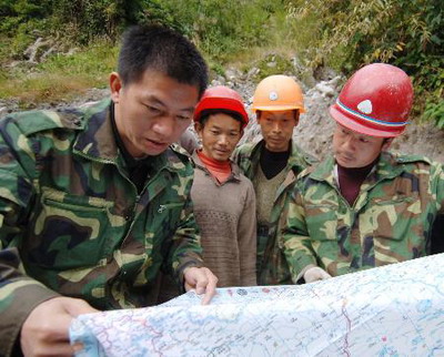 许晓珠(前左)与修路工人研究墨脱路塌方区修建方案.