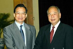 6月14日，中共中央政治局常委、書記處書記尉健行圓滿結束對科特迪瓦、加蓬、博茨瓦納和津巴布韋等非洲國家的訪問回到北京。中共中央政治局委員、國務院副總理溫家寶到人民大會堂迎接。新華社記者 饒愛民 攝