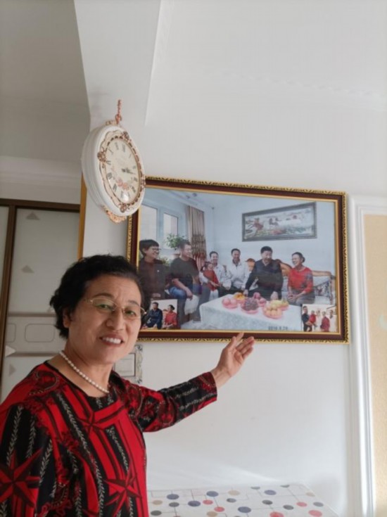 陈玉芳介绍习近平总书记到家中做客的照片。受访者供图