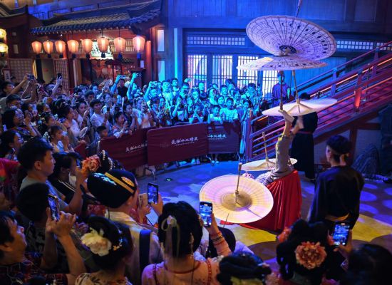 游客在長安十二時辰主題街區觀看唐風演藝《長安百藝》。新華社記者鄒競一 攝