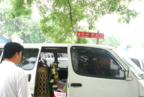运送花篮的汽车停在胡同口.(中国共产党新闻网记者 董宇摄)